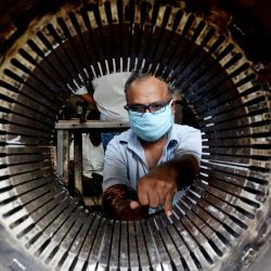 Un electricista trabaja en un motor en un taller después de que el gobierno alivió un bloqueo nacional impuesto como medida preventiva contra el coronavirus COVID-19, en Chennai, el 11 de mayo de 2020. (Foto de Arun SANKAR / AFP) | Foto:AFP