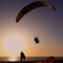 El parapente israelí Ohad se desliza desde un acantilado mientras el sol se pone en la ciudad costera israelí de Netanya el 10 de mayo de 2020. (Foto por JACK GUEZ / AFP) | Foto:AFP