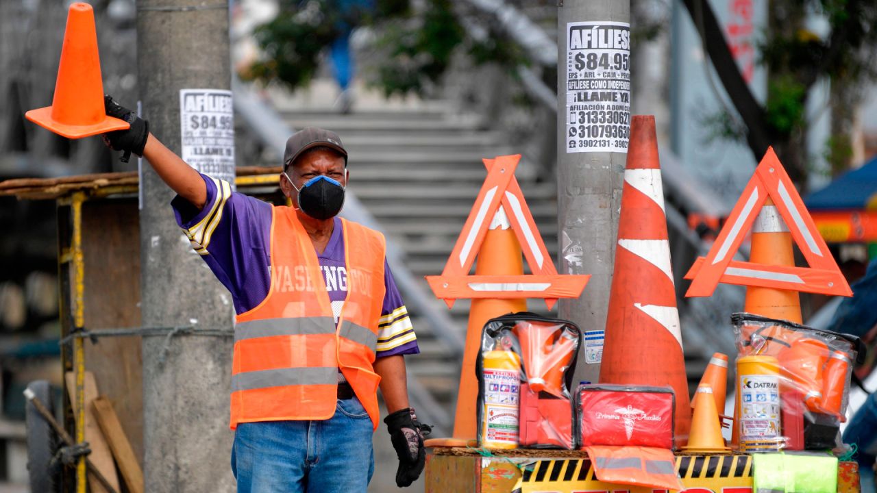 Un hombre que vende letreros de la calle usa una máscara facial como medida preventiva contra la propagación del coronavirus COVID-19, en Bogotá, el 11 de mayo de 2020. (Foto por Raúl ARBOLEDA / AFP) | Foto:AFP