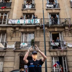 Un policía de la policía de la ciudad de Saint-Mande y los residentes aplauden a las 20:00 junto con otros en todo el país francés, para mostrar su apoyo a los empleados de la salud en Saint-Mande, un suburbio de París, el 11 de mayo de 2020, el primer día. de la reducción de las medidas de bloqueo de Francia durante 55 días para frenar la propagación de la pandemia de COVID-19, causada por el nuevo coronavirus. (Foto por Martin BUREAU / AFP) | Foto:AFP