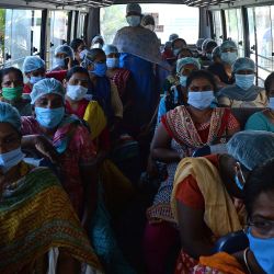 Las enfermeras con mascarillas se sientan en un autobús mientras regresan a casa después de 14 días de cuarentena mientras trabajaban en el hospital Rajiv Gandhi en Chennai el 12 de mayo de 2020, durante el Día Internacional de las Enfermeras, el aniversario del nacimiento de Florence Nightingale. (Foto por Arun SANKAR / AFP) | Foto:AFP