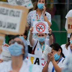 Los trabajadores de la salud sostienen un cartel que dice  | Foto:AFP