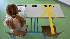 Una alumna de la escuela primaria Sainte-Croix trabaja mientras la mitad de su escritorio está marcada con una cinta adhesiva para garantizar que se mantenga una distancia segura el 15 de mayo de 2020 en Hannut, ya que el bloqueo se introdujo hace dos meses para luchar contra la propagación del Covid La enfermedad causada por el nuevo coronavirus se está aliviando progresivamente. (Foto por JOHN THYS / AFP)