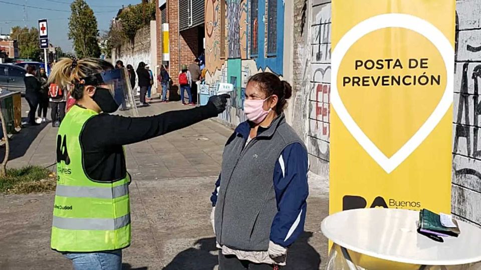 Medidas. Las mesas dan información y controlan la temperatura a vecinos que se acercan.