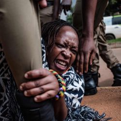 Stella Nyanzi (C), una destacada activista ugandesa y crítica del gobierno, es arrestada por agentes de policía mientras organizaba una protesta por una mayor distribución de alimentos por parte del gobierno a las personas que han estado luchando financieramente por el bloqueo nacional impuesto para frenar la propagación del COVID. -19 coronavirus en Kampala, el 18 de mayo de 2020. (Foto de SUMY SADURNI / AFP) | Foto:AFP