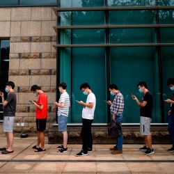 Los empleados de Huawei esperan un autobús de enlace en la sede de la compañía en Shenzhen, en la provincia de Guangdong, en el sur de China, el 19 de mayo de 2020. - Huawei atacó el 18 de mayo el último movimiento de Estados Unidos para cortarlo de los proveedores de semiconductores como un ataque  | Foto:AFP
