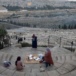 Los palestinos se reúnen para romper su ayuno durante el mes sagrado musulmán del Ramadán, en el Monte de los Olivos con el telón de fondo de la Ciudad Vieja de Jerusalén y el recinto cerrado de la Mezquita al-Aqsa el 19 de mayo de 2020, durante la nueva crisis pandémica de coronavirus. (Foto por Ahmad GHARABLI / AFP) | Foto:AFP