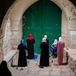 Las adoradoras palestinas musulmanas, distanciadas entre sí debido a la pandemia del coronavirus COVID-19, rezan frente a la puerta cerrada del complejo de la mezquita de Aqsa en la Ciudad Vieja de Jerusalén, mientras marcan el Lailat al-Qadr, una de las noches más santas durante el mes de ayuno musulmán del Ramadán, a finales del 19 de mayo de 2020. - Lailat al-Qadr (Noche del Destino) marca la noche en que los musulmanes creen que los primeros versos del Corán fueron revelados al profeta Mahoma a través del arcángel Gabriel. (Foto por AHMAD GHARABLI / AFP) | Foto:AFP