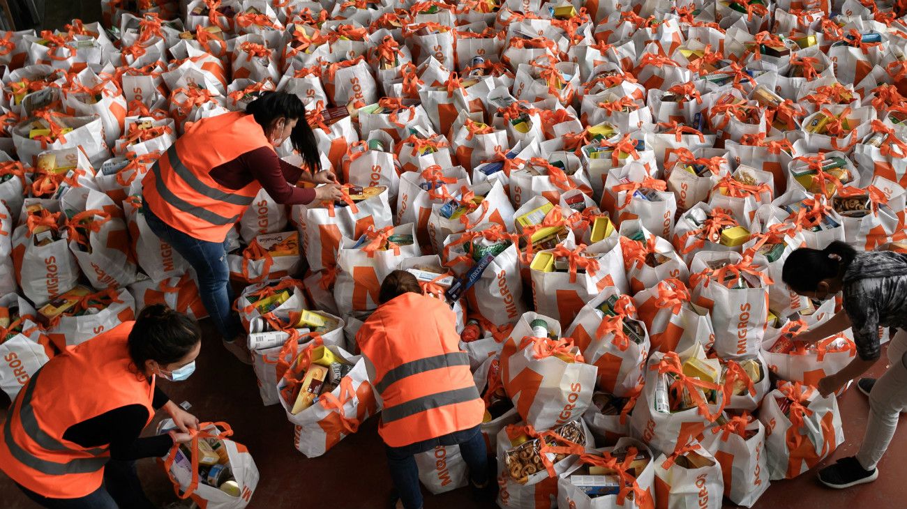 Voluntarios preparan bolsas con comida para distribuir a los necesitados en Ginebra, Suiza