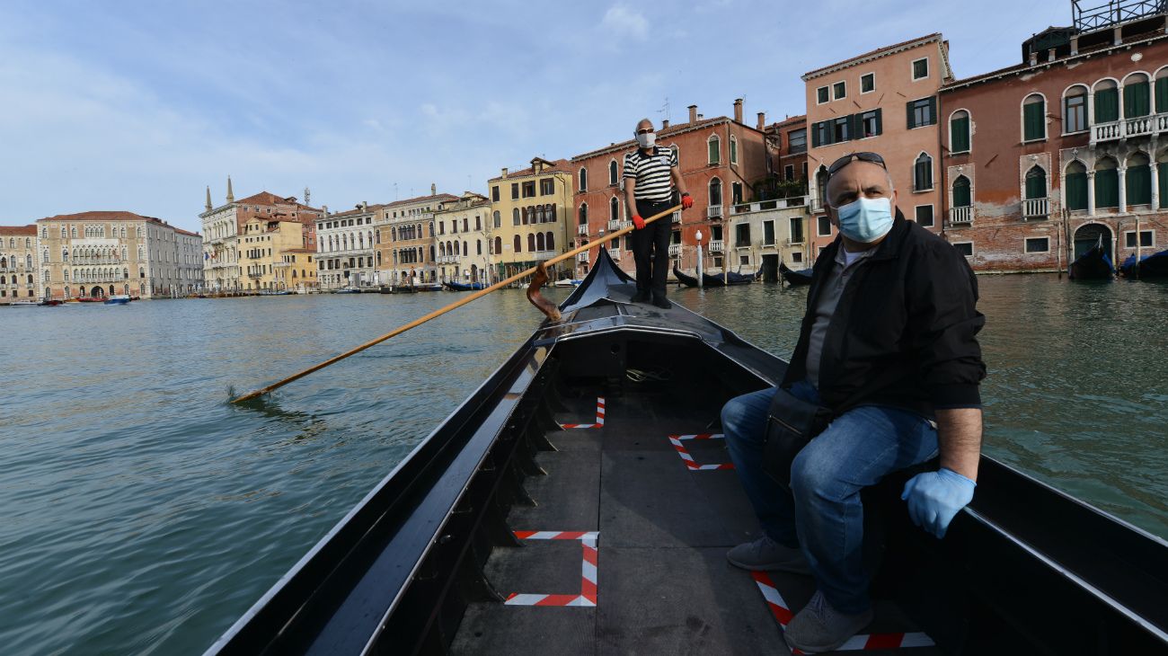 Un gondolero transporta a su primer cliente al reanudarse el servicio en el terraplén de San Toma, Venecia, Italia