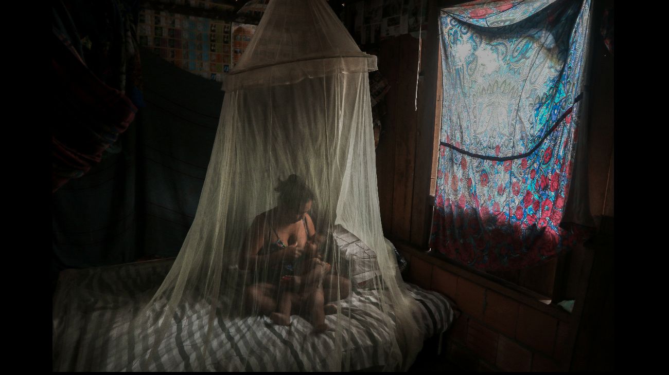 Una madre indígena amamanta a su hijo en una cama protegida tras ser tratada con hierbas por síntomas de covid-19 en la comunidad de Wakiru, Manaus, Amazonas, Brasil