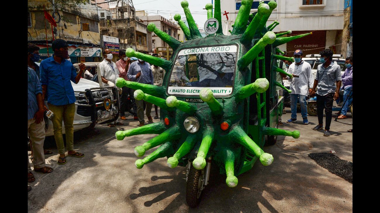 Chennai, India: Un trabajador municipal conduce un auto-rickshaw temático del coronavirus tras la flexibilización de la cuarentena