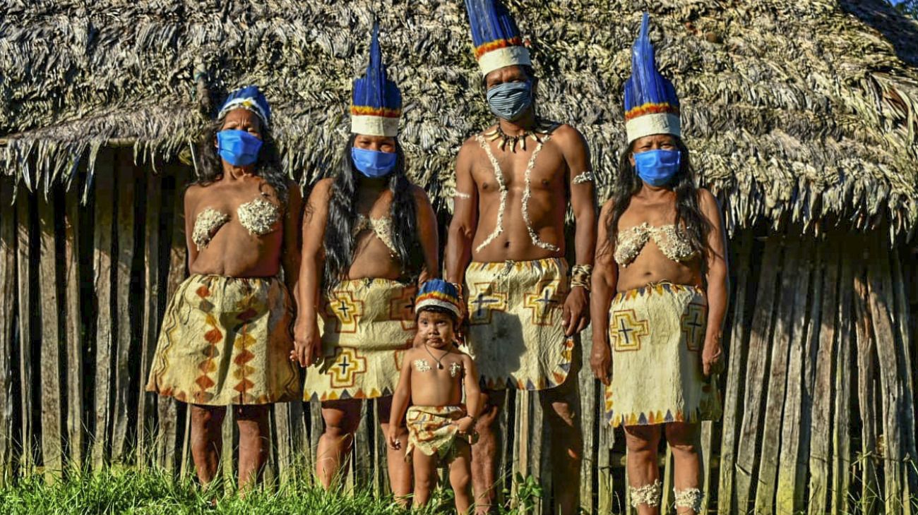 Los indígenas huitoto colombianos posan con máscaras faciales en Leticia, departamento de Amazonas, Colombia