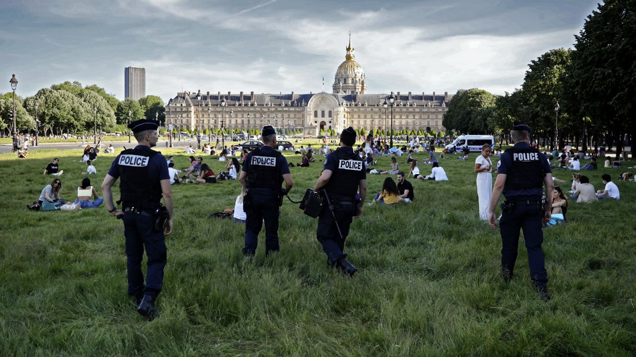 París, Francia: La policía pide a las personas que disfrutan de un día soleado que mantengan su distancia, frente al hotel des Invalides en París