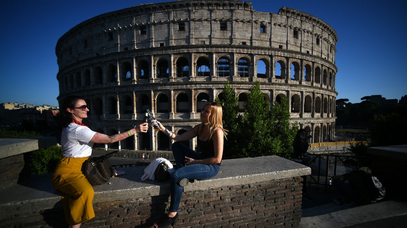 Roma, Italia: Dos mujeres brindan con cerveza junto al monumento del Coliseo