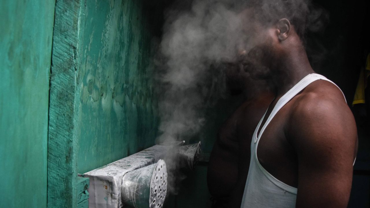 Un hombre inhala vapores en una cabina instalada por el herbolario tanzano Msafiri Mjema en Dar es Salaam, Tanzania, el 22 de mayo de 2020 como tratamiento preventivo contra el coronavirus COVID-19. - Las personas que deseen someterse al tratamiento pagarán 1000 chelines tanzanos (alrededor de menos de medio dólar estadounidense) para ingresar a la cabina e inhalar vapores de agua y sal, durante 5 a 10 minutos. Las inhalaciones de vapor son un tratamiento tradicional popular para la gripe, la fiebre alta y la malaria. El presidente de Tanzania, John Magufuli, dijo que uno de sus hijos había contraído el coronavirus COVID-19 y se había recuperado gracias a las inhalaciones de vapor con limones y jengibre. Tanzania es uno de los pocos países de África que no ha tomado medidas exhaustivas contra el virus. (Foto por Ericky BONIPHACE / AFP) | Foto:AFP