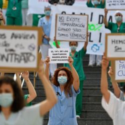 Un trabajador de la salud tiene un letrero que dice  | Foto:AFP