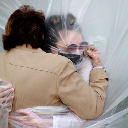 WANTAGH, NUEVA YORK - 24 DE MAYO: Olivia Grant (R) abraza a su abuela, Mary Grace Sileo a través de una tela plástica colgada en una línea de ropa casera durante el fin de semana del Memorial Day el 24 de mayo de 2020 en Wantagh, Nueva York. Es la primera vez que han tenido contacto de cualquier tipo desde que el bloqueo de la pandemia del coronavirus COVID-19 comenzó a fines de febrero. Al Bello / Getty Images / AFP | Foto:AFP