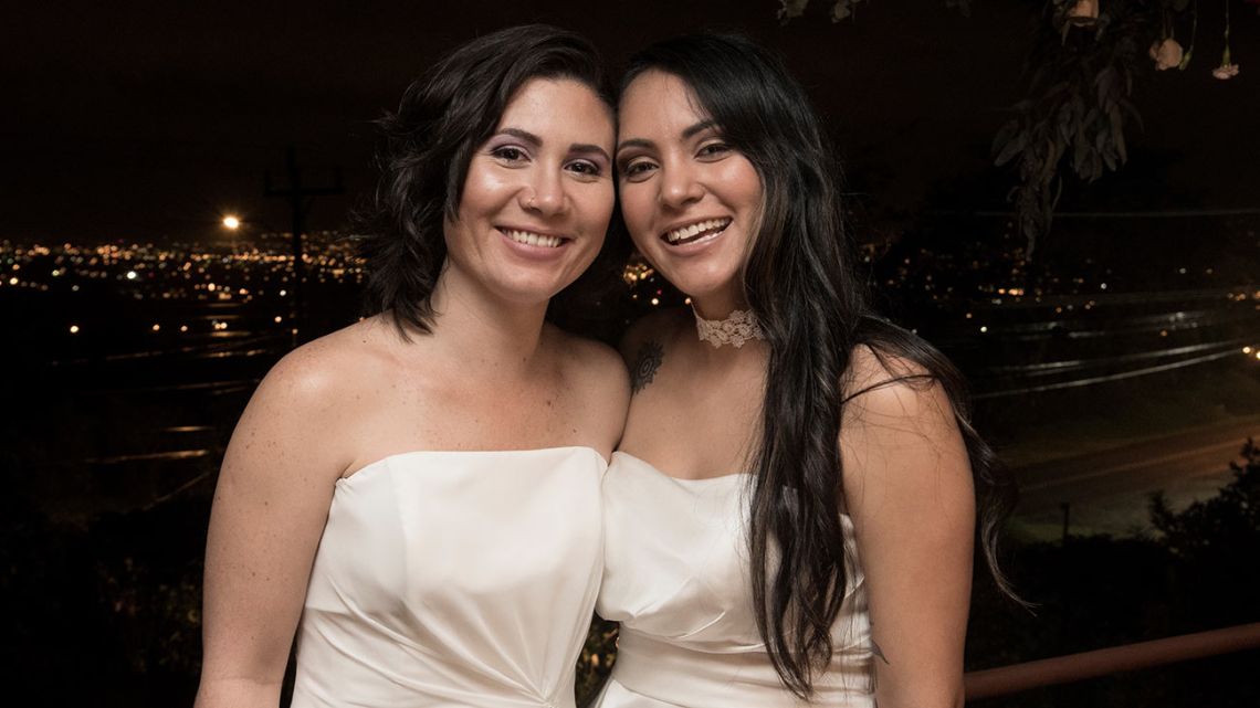 Same-sex newlyweds Alexandra Quiros (L) and Dunia Araya (R) pose during their wedding in Heredia, Costa Rica, on May 26, 2020. Costa Rica legalised same-sex marriage on May 26, becoming the first Central American country to do so and sparking an emotional response from rights campaigners as the first weddings were held overnight. 