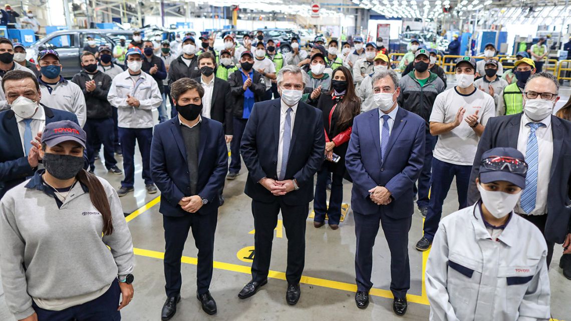 Handout photo released by the Presidency shows President Alberto Fernández (centre) and Buenos Aires Province Governor Axel Kicillof (second left) posing with employees from the Toyota production plant in Zárate on May 27, 2020. 