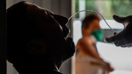 Un trabajador de salud toma una muestra para una prueba COVID-19 durante una prueba aleatoria en el barrio de Aranjuez en Medellín, Colombia, el 27 de mayo de 2020. (Foto de JOAQUIN SARMIENTO / AFP)