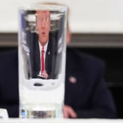 El presidente de los Estados Unidos, Donald Trump, es visto a través de un vaso mientras toma parte en una mesa redonda con ejecutivos de la industria sobre la reapertura del país, en el Comedor Estatal de la Casa Blanca en Washington, DC. (Foto por MANDEL NGAN / AFP) | Foto:AFP