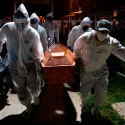 Los sepultureros con ropa protectora llevan el ataúd de una víctima del nuevo coronavirus COVID-19 para su entierro en el Cementerio Municipal de Recanto da Paz en la ciudad de Breves, al suroeste de la isla de Marajo, una isla en la desembocadura del río Amazonas en el Brasil estado de Pará. | Foto:Tarso Sarraf / AFP)