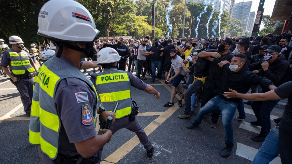 Police clash with demonstrators during a protest against fascism, President Jair Bolsonaro and to defend democracy in Sao Paulo, Brazil, Sunday, May 31, 2020. Police used tear gas to disperse anti-government protesters in Brazil's largest city as they began to clash with small groups of demonstrators loyal to President Jair Bolsonaro.