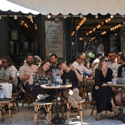 Personas comen y toman bebidas en la terraza del café restaurante Le Compat en París, mientras los cafés y restaurantes reabran en Francia, mientras el país alivia las medidas de bloqueo tomadas para frenar la propagación del COVID-19 (el nuevo coronavirus). | Foto:BERTRAND GUAY / AFP