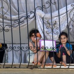 Las jóvenes palestinas se sientan en el alféizar de la ventana en la ciudad de Gaza en medio de la nueva crisis pandémica de coronavirus. | Foto:MOHAMMED ABED / AFP