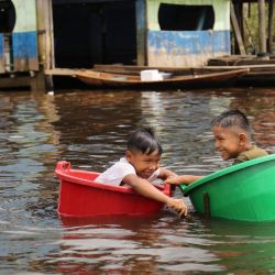 Los niños flotan en baldes en el río Amazonas en la comunidad del puerto de Belén en Iquitos, Perú, en medio de la nueva pandemia de coronavirus.  | Foto:Cesar Von Bancels / AFP