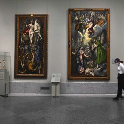 Una empleada de seguridad, llevando tapaboca, pasa frente la obra de El Greco en el Museo del Prado en Madrid. | Foto:AFP