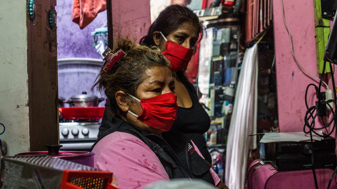 Gloria (front) and Lidia wait with their face masks on for the arrival of the sex workers from the Miluska Life and Dignity Association, a local umbrella group caring for sex workers, to serve meals from a daily communal kitchen in downtown Lima on May 28, 2020.