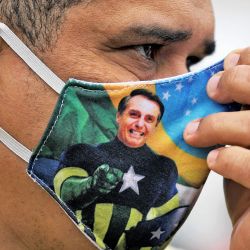 Un partidario del presidente Jair Bolsonaro usa una máscara facial con la imagen de Bolsonaro durante una manifestación en la playa de Copacabana en Río de Janeiro, Brasil. | Foto:CARL DE SOUZA / AFP