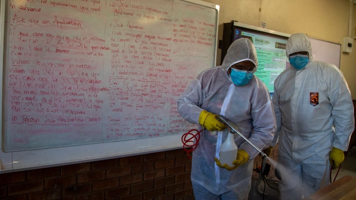 Disinfection team disinfect a classroom at Ivory Park Secondary School east of Johannesburg, South Africa, Thursday, May 28, 2020, ahead of the June 1, 2020, re-opening of Grade 7 and 12 learners to school.