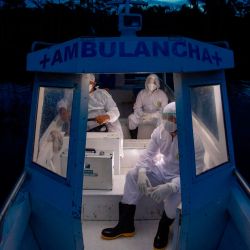 Los trabajadores de la salud de la ciudad de Melgaco viajan en una ambulancia en barco de regreso después de visitar a ocho familias que viven sin electricidad en una pequeña comunidad ribereña en el río Quara, en medio de la preocupación por la propagación del coronavirus COVID-19, en el suroeste de Marajo. Isla, estado de Pará, Brasil. | Foto:TARSO SARRAF / AFP