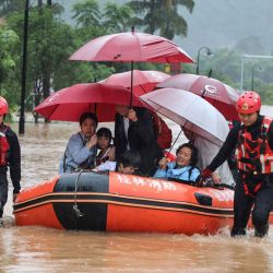 Esta foto muestra a los rescatistas que evacuan a las personas en un área inundada después de fuertes lluvias en Yangshuo, en la región de Guangxi, en el sur de China.  | Foto:STR / AFP
