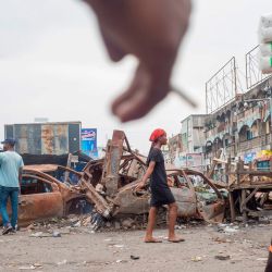 La gente camina frente a una barricada en el mercado de Kinshasa Grand, durante una manifestación en la que los manifestantes solicitan la reapertura de las tiendas que el gobierno ha cerrado como medida de precaución contra la propagación del COVID. -19 coronavirus. - Al menos tres personas fueron reportadas muertas por las autoridades locales.  | Foto:ARSENE MPIANA / AFP