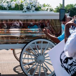 Los dolientes observan cómo el ataúd de George Floyd es transportado por un carruaje tirado por caballos blancos hasta su lugar de descanso final en el cementerio de Houston Memorial Gardens en Pearland, Texas. | Foto:ANDREW CABALLERO-REYNOLDS / AFP