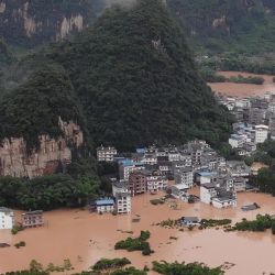 Esta foto muestra calles sumergidas y edificios inundados después de que fuertes lluvias causaron inundaciones en Yangshuo, en la región meridional china de Guangxi.  | Foto:STR / AFP