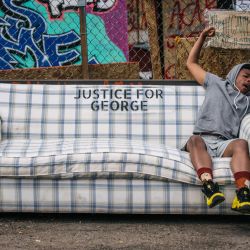 Un hombre se estira en un sofá en un sitio conmemorativo para George Floyd en Minneapolis, Minnesota. La gente se ha estado reuniendo en el sitio conmemorativo desde que George Floyd fue asesinado el 25 de mayo de 2020 por agentes del Departamento de Policía de Minneapolis.  | Foto:Brandon Bell / Getty Images / AFP