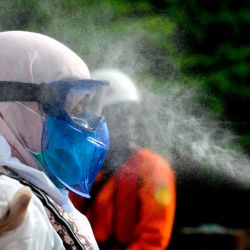 Un funcionario de cuarentena de salud de Indonesia vistiendo un equipo de protección en medio del desinfectante de aerosoles antipandémicos de coronavirus COVID-19 después de una evacuación médica en el mar, frente a la costa de Aceh. | Foto:PRESIDENTE MAHYUDDIN / AFP