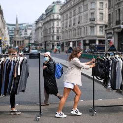 Los trabajadores minoristas mueven rieles de ropa entre las tiendas en Oxford Street en Londres, ya que los minoristas no esenciales, obligados a cerrar debido a la pandemia de COVID-19, se preparan para volver a abrir. | Foto:DANIEL LEAL-OLIVAS / AFP