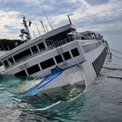 Un ferry aparece hundiéndose en el puerto de ferry de Padangbai en Karangasem, en la isla de Bali. Más de 60 pasajeros y tripulantes fueron rescatados del ferry, que también transportaba vehículos de carretera, incluidos varios camiones, sin que se informaran víctimas.  | Foto:SONNY TUMBELAKA / AFP