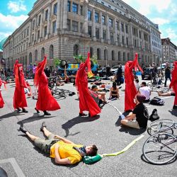 Activistas del movimiento Rebelión de la Extinción bloquean una calle frente a la Asociación Alemana de la Industria del Automóvil durante una protesta en Berlín | Foto:Tobias Schwarz / AFP