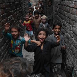 Los niños de los refugiados afganos juegan en un barrio pobre en Lahore, antes del Día Mundial de los Refugiados. | Foto:Arif Ali / AFP