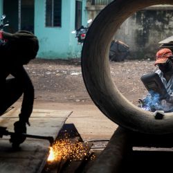Los trabajadores sueldan piezas en estructuras de acero en un taller en Dhaka. | Foto:MUNIR UZ ZAMAN / AFP