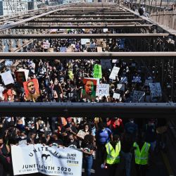 Los manifestantes cruzan el puente de Brooklyn hacia Manhattan en la ciudad de Nueva York. - Los Estados Unidos marcan el fin de la esclavitud celebrando con el feriado anual no oficial que adquiere una importancia renovada a medida que millones de estadounidenses confrontan el legado vivo de la nación de la injusticia racial.  | Foto:Angela Weiss / AFP