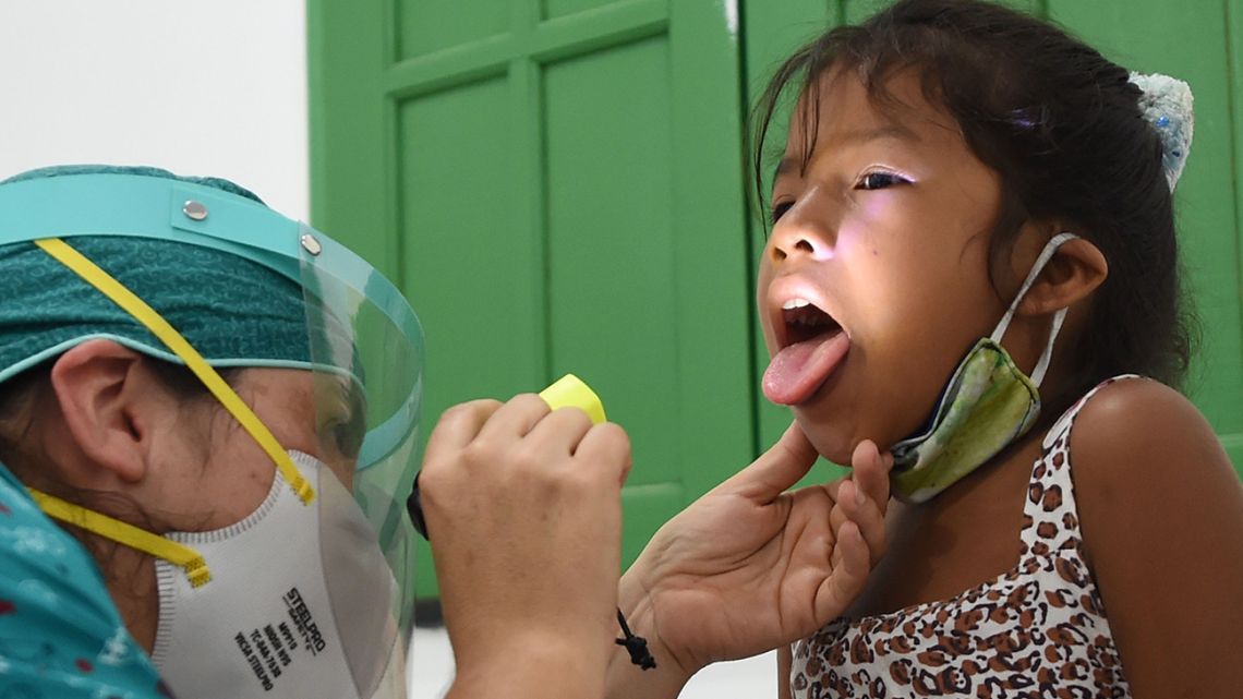 An indigenous girl of the Ticuna ethnic group receives medical assistance at a health post in the Umariacu village, Tabatinga, Amazonas state, Brazil, on June 19, 2020, amid the new coronavirus pandemic. The municipality restricted access to indigenous areas to try to prevent indigenous populations from contracting COVID-19. 