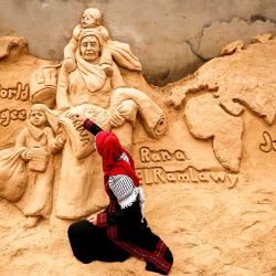 La escultora de arena palestina Rana Ramlawi termina una nueva creación artística que conmemora el Día Mundial de los Refugiados. | Foto:MOHAMMED ABED / AFP